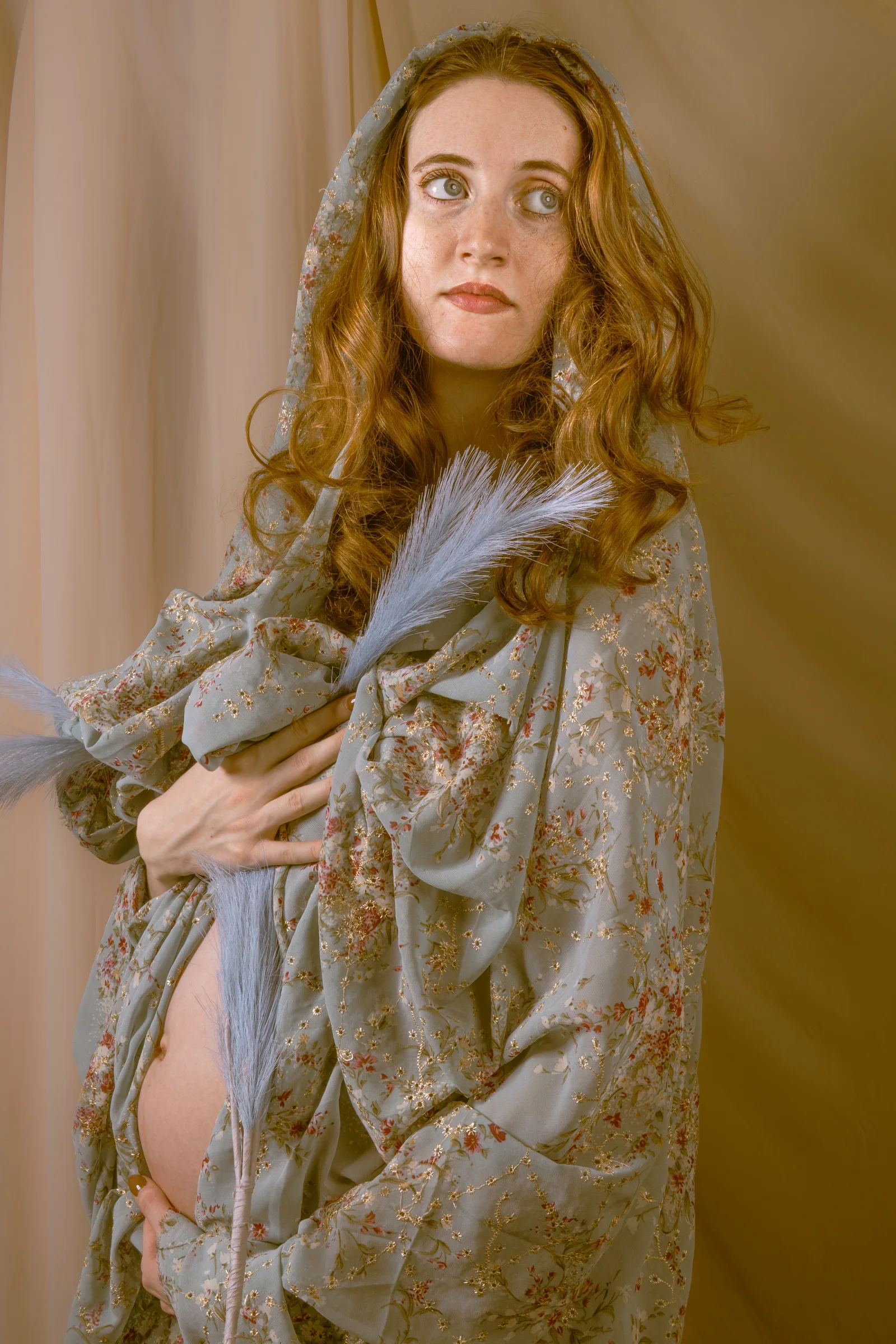 Portrait in soft draped fabric beside a window