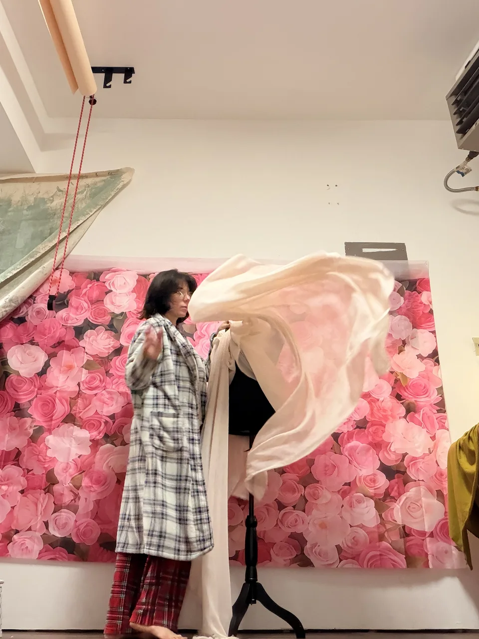 Lidi arranging fabric in front of a pink floral backdrop