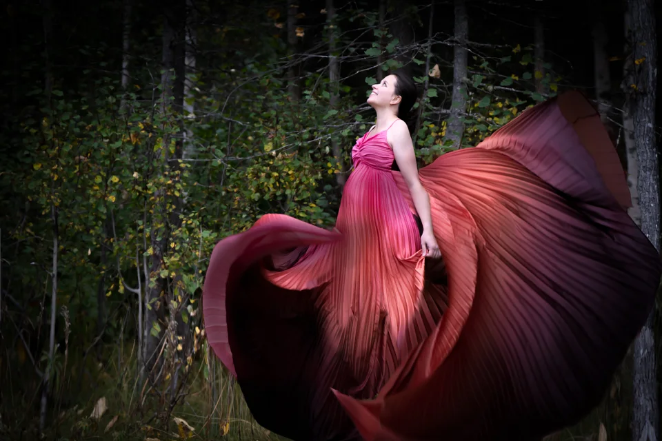 Outdoor maternity portrait with flowing burgundy fabric