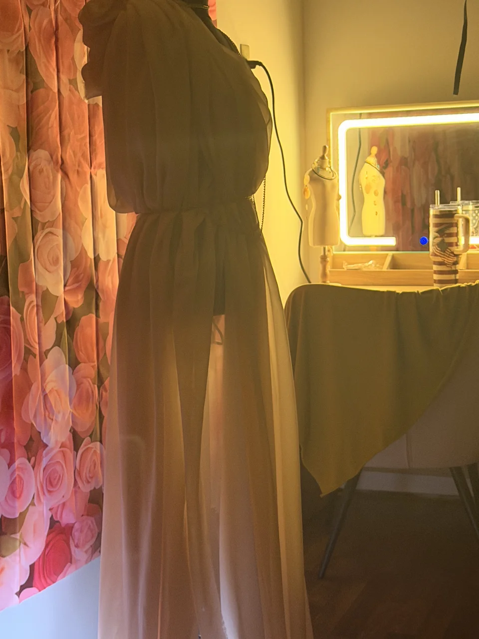 A dress form beside warm light in the workroom