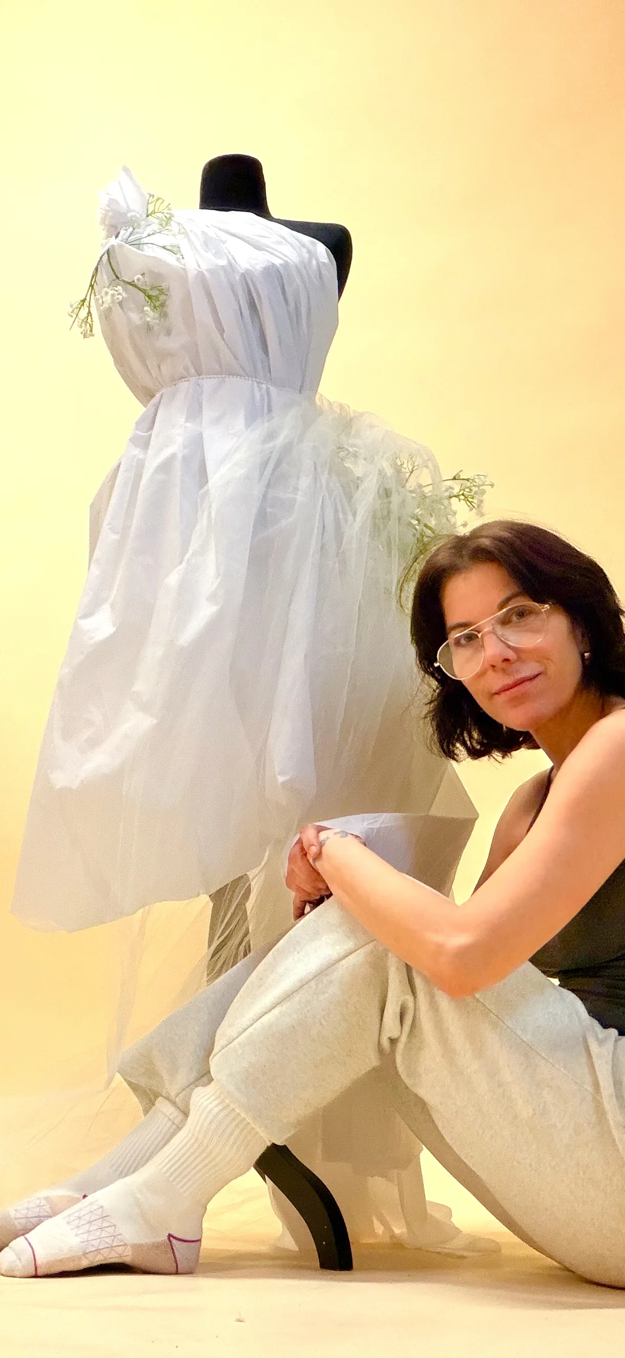 Lidi working beside a white dress on a mannequin