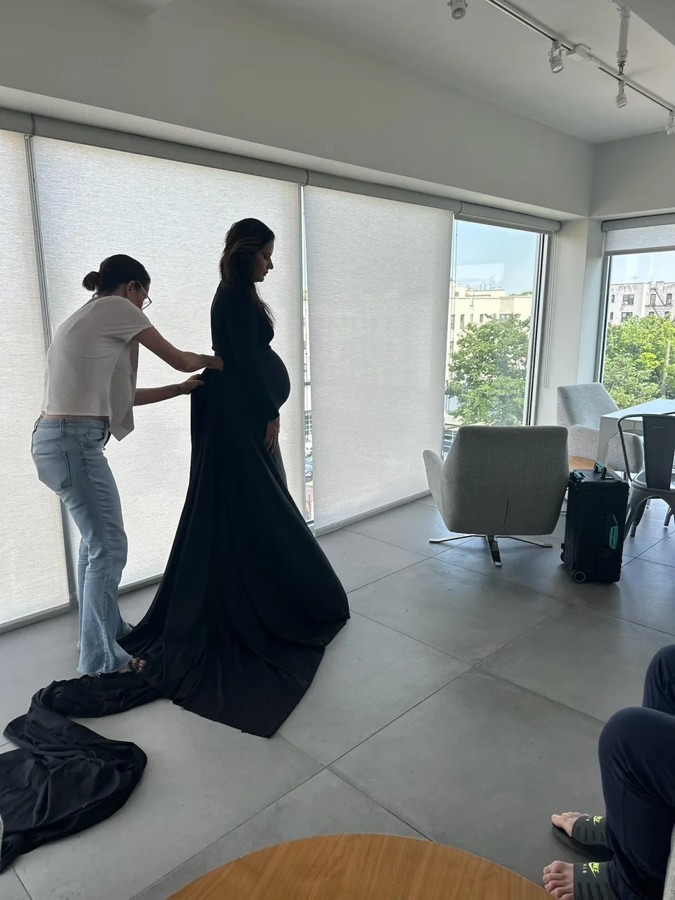 Photographer adjusting a model’s pose beside a window