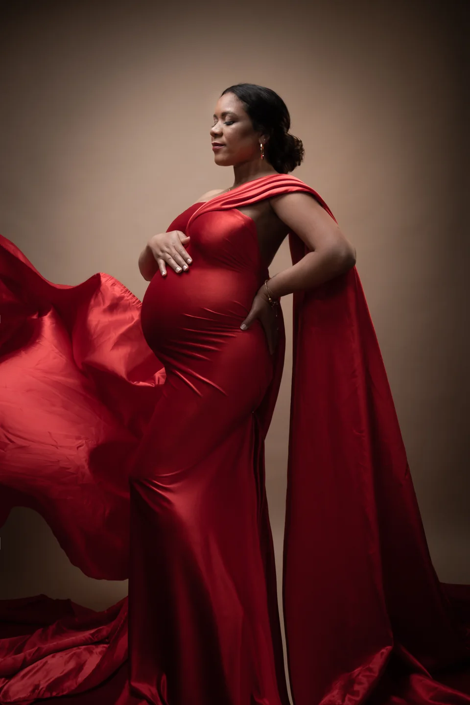 Maternity portrait in profile with red fabric in motion