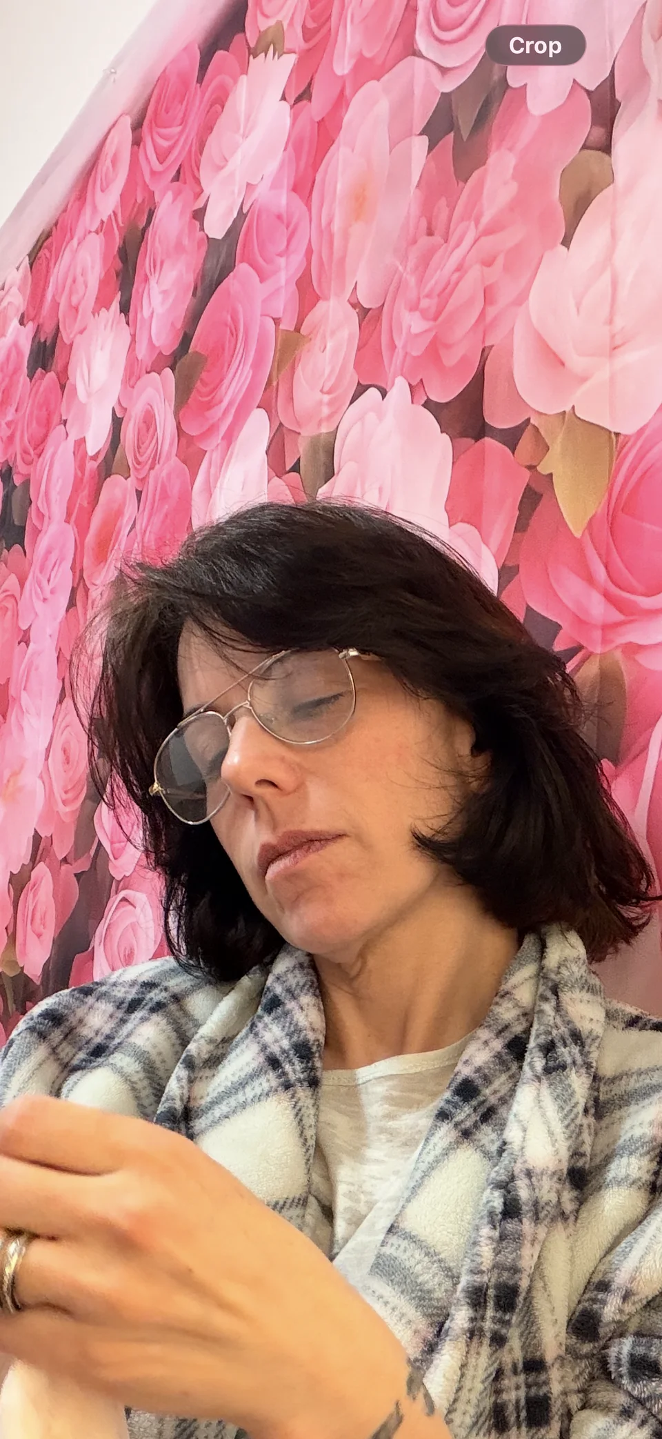 Lidi working on a garment beside a floral backdrop