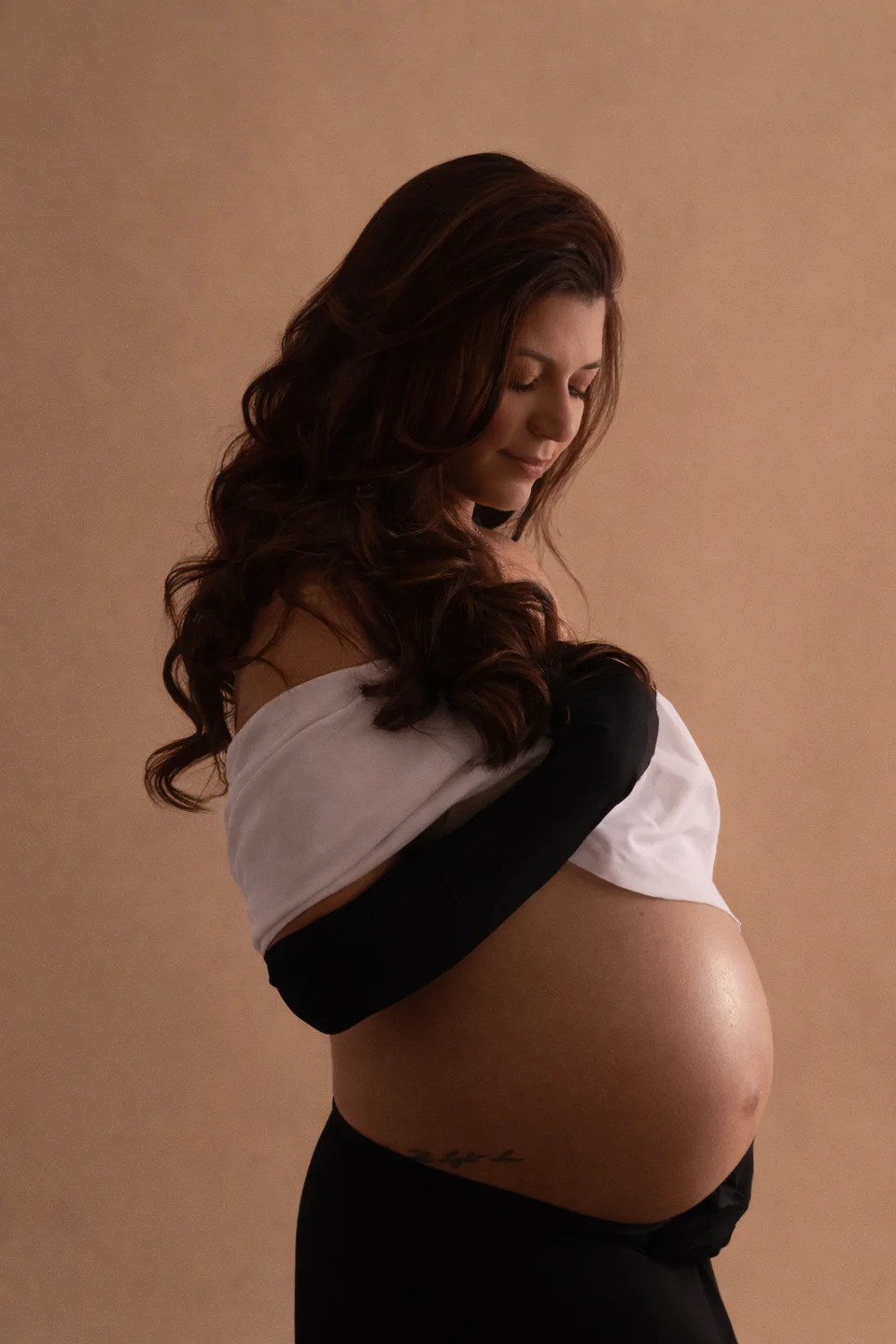 Maternity portrait in profile with black and gray fabric