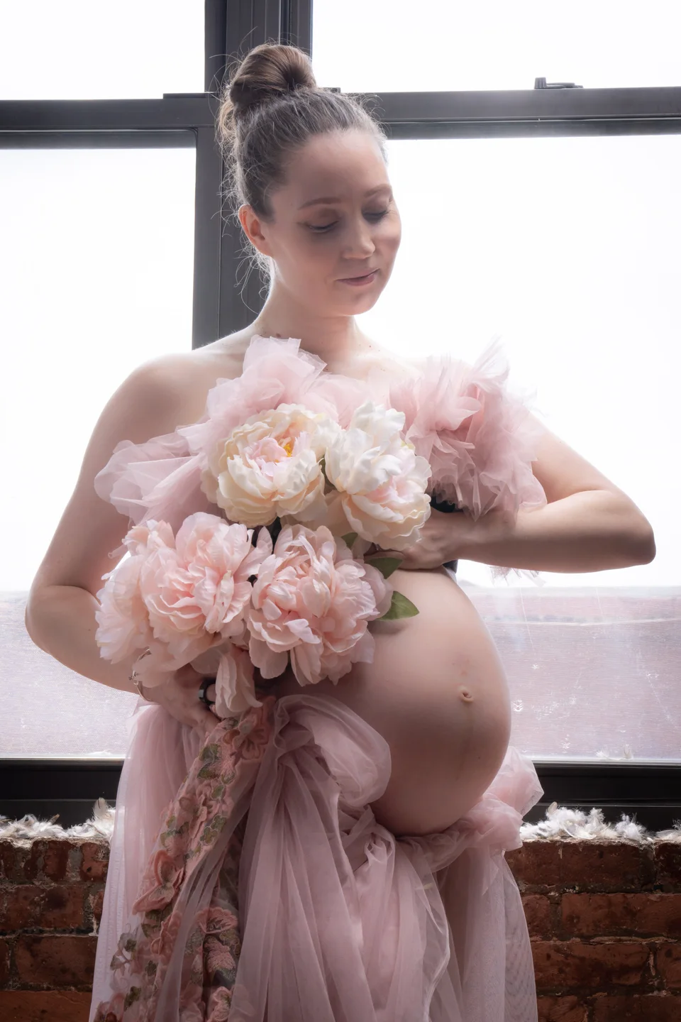 Maternity portrait in a pink dress with a bouquet