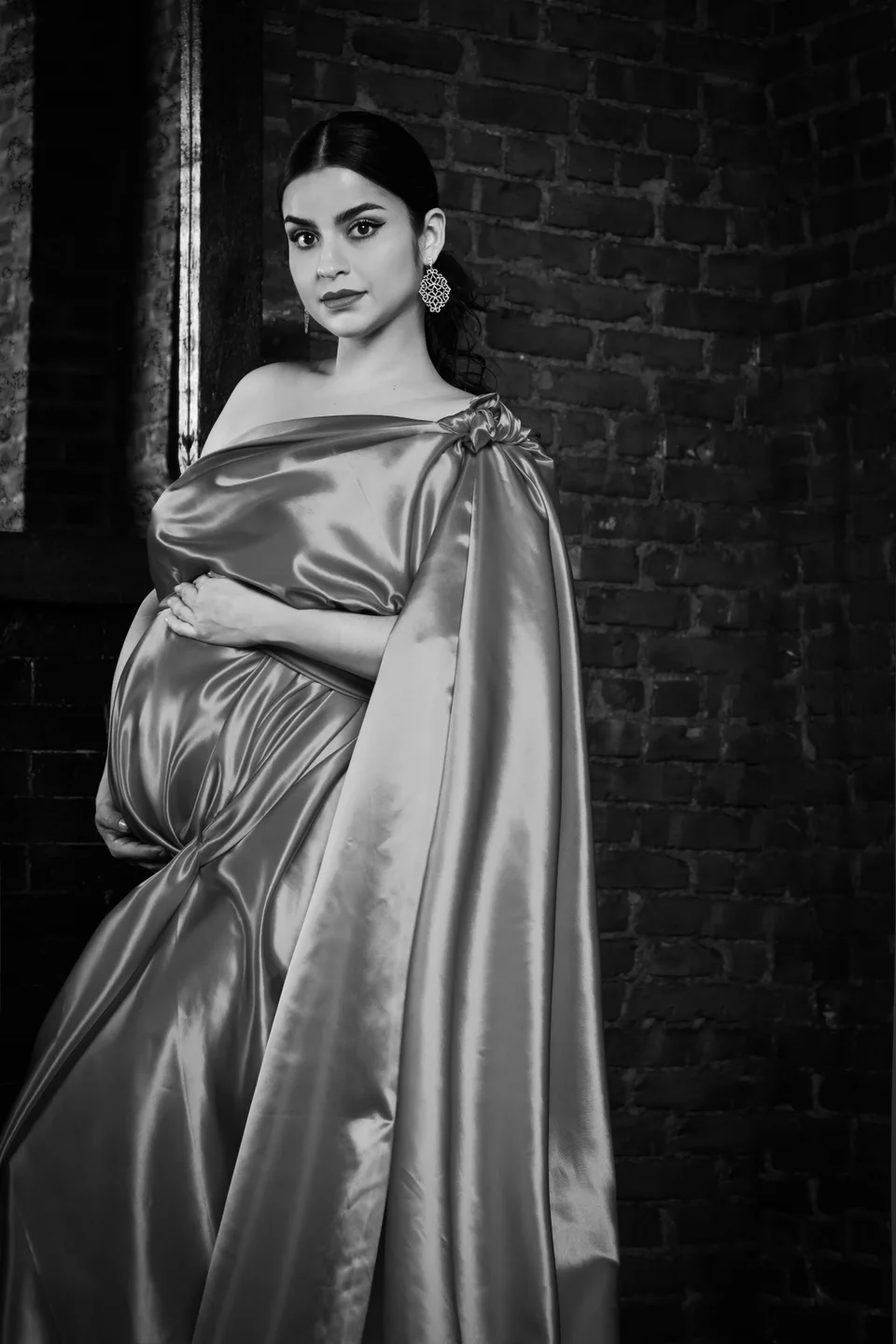Black-and-white maternity portrait with a satin wrap