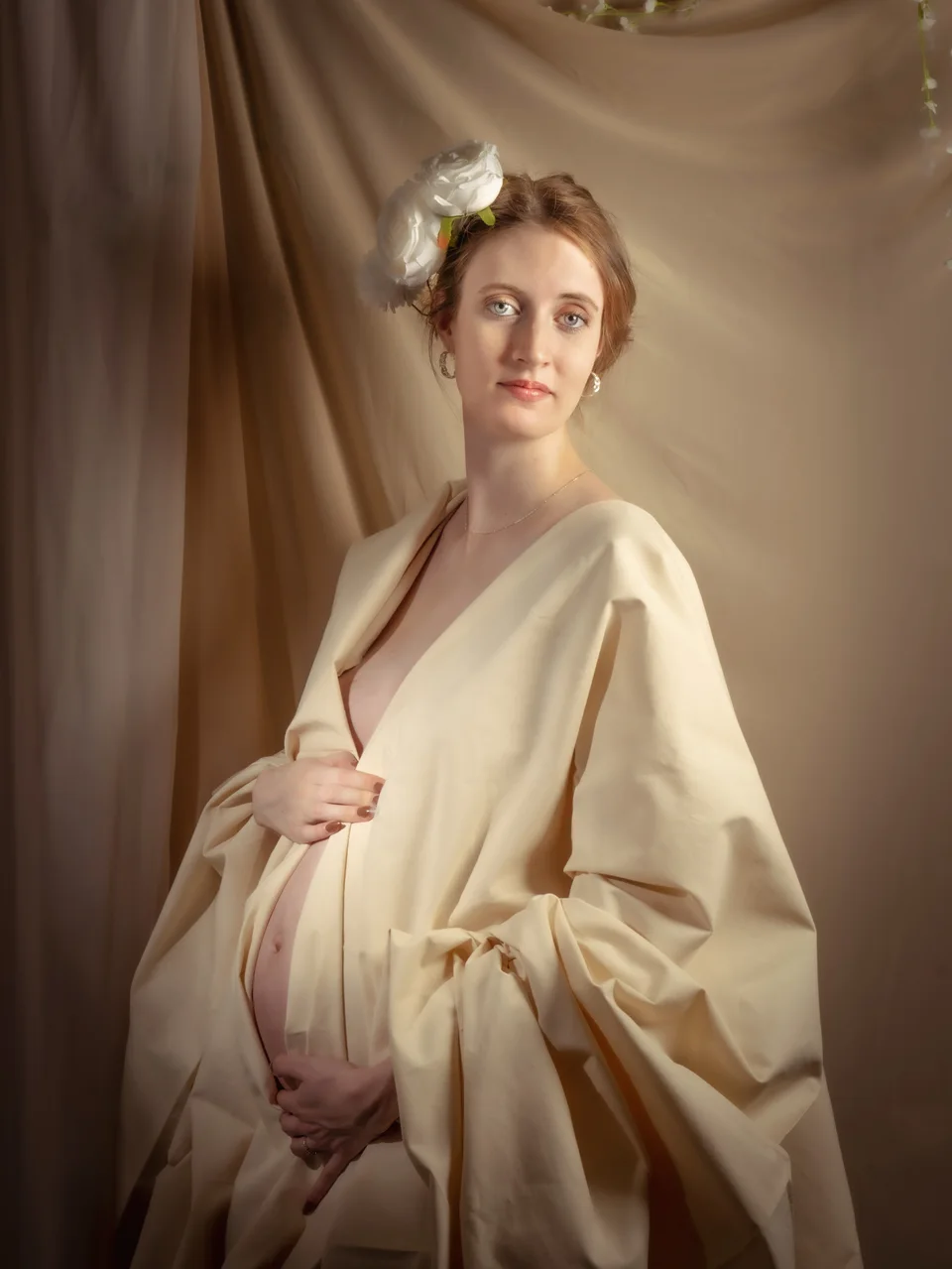 Maternity portrait in cream fabric with a sculptural headpiece